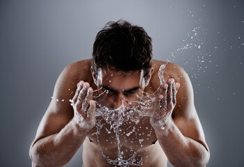 Water drops, splash and man cleaning face for bathroom routine, dermatology cleanse or beauty...