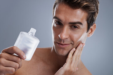 Studio, portrait and man with aftershave for beauty, grooming and facial treatment or cologne....