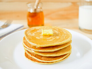 Stack of pancakes with butter and honey