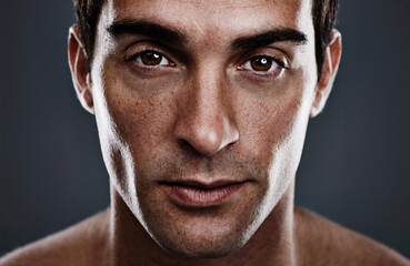 Fototapeta premium Portrait, skincare and man with cosmetics, glow and grooming on grey studio background. Person, guy and model with routine or treatment with beauty and shine with beauty, wellness or dermatology