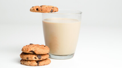 Chocolate chip cookies and a glass of milk coffee on a white background