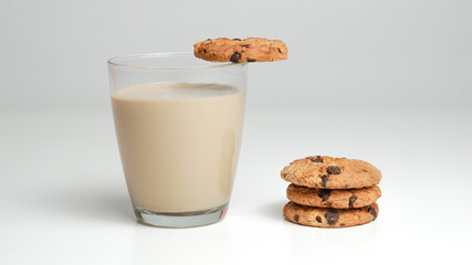 Chocolate chip cookies and a glass of milk coffee on a white background