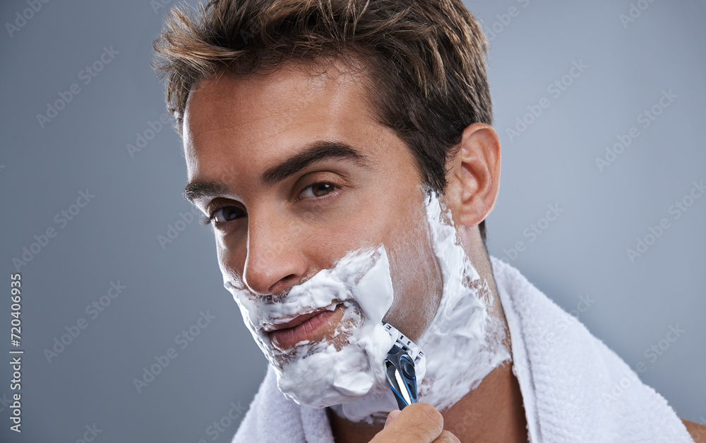 Canvas Prints Man, blade and shaving beard in studio closeup for grooming, skincare and portrait by grey background. Person, model and self care with cream, facial hair removal and product for cosmetic change