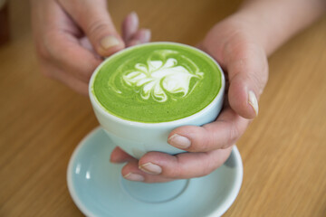 Hand holding a coffee cup, sipping coffee.