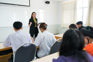 Asian female university explaining lesson to the students in the classroom