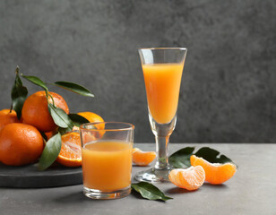 Delicious tangerine liqueur and fresh fruit on grey table, space for text