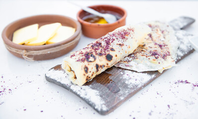 front view of layout with delicious pita lying on wooden board with cheese and honey outdoors. Concept of food.