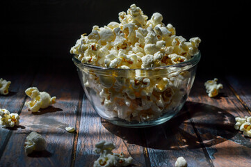 A pile of salted popcorn, in glass bowl.