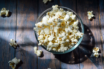 A pile of salted popcorn, in glass bowl.