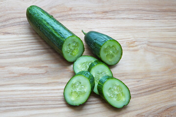 Green, long cucumber cut into slices on a wooden board, for natural, dietary nutrition, for a healthy diet.