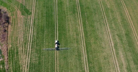 Tractor Spraying Pesticides on Crops at Agriculture Field