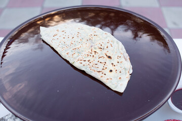Above view of crispy shawarma, pita, taco being cooked, lying on frying pan with oil outdoors....