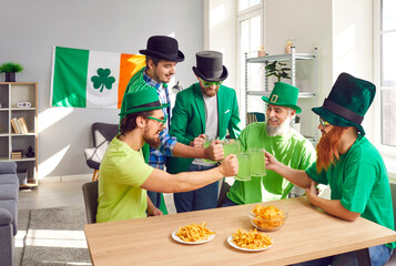 Five male friends enjoying St Patrick's Day party. Group of happy men in green hats, T shirts and...