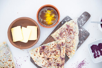 Above view of stylish wooden board with wrapped pita lying on table with cheese, honey ad jam. Concept of fast food.