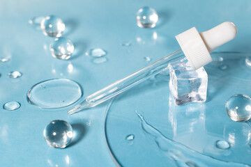 Drug development. Skin care cosmetics. Medical pipette on a blue background. The liquid essence flows