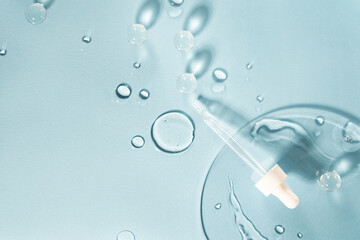 Drug development. Skin care cosmetics. Medical pipette on a blue background. The liquid essence flows
