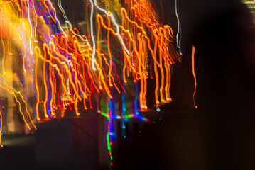 Out of focus blurred holiday celebration lights on dark background.