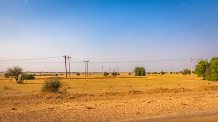 Wind turbines and transmission tower for renewable electric power production in India's second largest onshore wind farm of Jaisalmer windpark in Jaisalmer district of Rajasthan state.