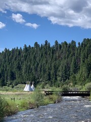 View of three teepees along Rock Creek in Montana