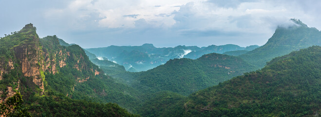 Panoramic view of Pachmarhi valley having clouds and mist shrouded hills rolling on each other from vantage point Priyadarshini Point in Pachmarchi, Madhya Pradesh, India.