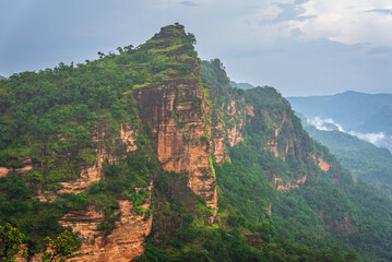 Panoramic view of Pachmarhi valley having clouds and mist shrouded hills rolling on each other from vantage point Priyadarshini Point in Pachmarchi, Madhya Pradesh, India.