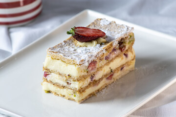 A slice of creamy puff pastry cake topped with strawberries