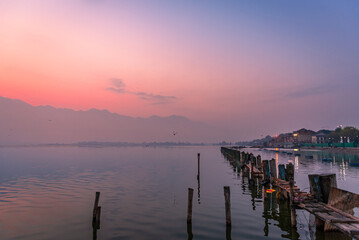 Obraz premium Panoramic landscape of Dal Lake nestled in Himalayas mountain range during sunrise on autumn morning from lake view point at Srinagar, Jammu and Kashmir, India.