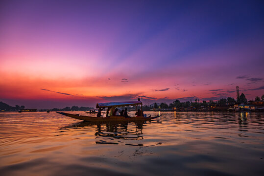 View of Dal Lake during sunset and the beautiful mountain range in the background in the city of Srinagar, Kashmir, India. It is a popular tourist destination for houseboats and shikara boats.