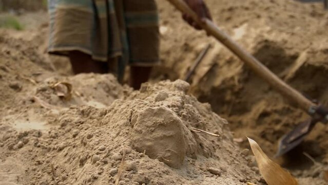 Indian laborer digging lang with traditional indian shovel in slow motion. Traditional Indian construction. 4K Indian worker digging a ditch