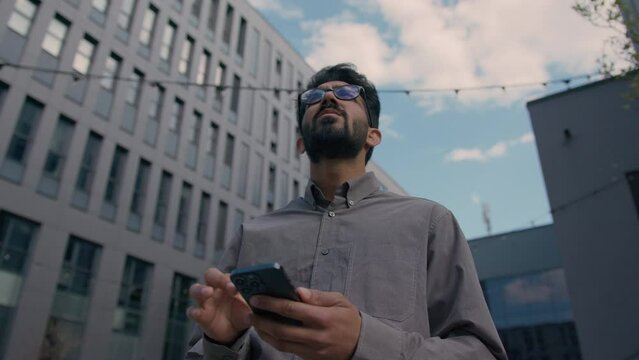 Arabian Indian business man looking direction search way with smartphone navigator gps map male businessman lost in city look for urban location use phone gadget outdoors mobile navigation geolocation