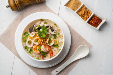 Seafood Porridge,Boiled rice soup with Sliced fish squid and shrimp in white bowl.Asian breakfast...
