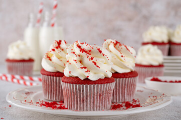 Red velvet cupcakes with cream cheese frosting and red sugar hearts. Delicious dessert for Valentines day. Selective focus, copy space.