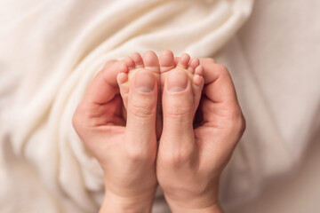 Baby feet of a newborn in dad's hands. On a white background.