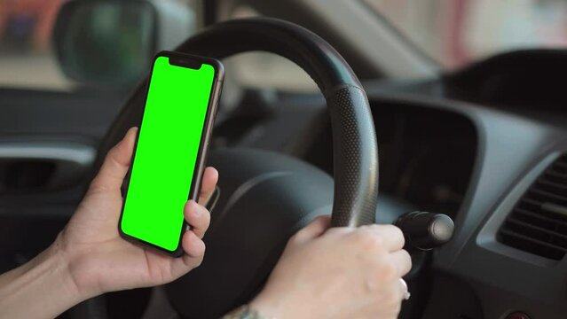 hand using phone green screen in car