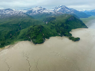 Tuxedni Bay on Cook Inlet at Lake Clark National Park in Alaska. Aerial view of estuary, tidal flats or mud flats, salt water marshes, and Chingmit mountains. Native owned fishing camp. 