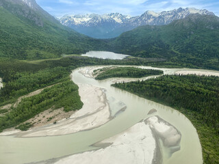 Lake Clark National Park and Preserve in Alaska. Braided alpine rivers full of snowmelt. Aerial view over rugged and remote mountains. 