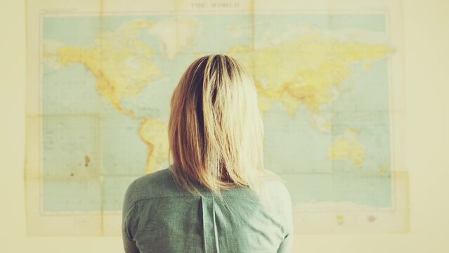 Travel, map and back of woman with poster planning holiday, vacation and tourist destination. Thinking, geography and person with earth, country and world navigation for adventure, location or choice