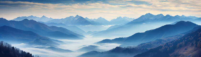 Fototapeta na wymiar Panoramic view of a majestic mountain range enveloped in morning mist under soft dawn sky.