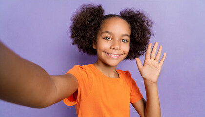 Close up little kid teen girl of African American ethnicity wear orange t-shirt do selfie shot mobile cell phone wave hand greet isolated on plain pastel purple background Childhood lifestyle concept