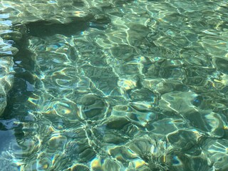 Stones and pebbles at the bottom of sea clear transparent water.