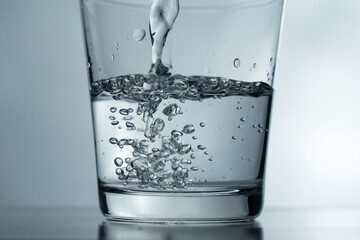 close-up Filling a glass with water showing a drink concept. bubbles in fresh water with white...