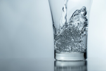 pouring water into glass on table, glass of water with splash isolated on white background. clean water for a good health. Mineral water in glass. 