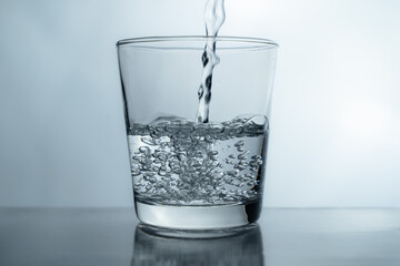 Filling a glass with water showing a drink concept. bubbles in fresh water with white background. 