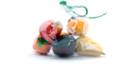 closeup of a bag of various marzipan fruit on white background