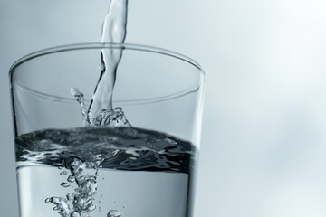 pouring water into glass on table, glass of water with splash isolated on white background. clean water for a good health. Mineral water in glass. 