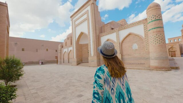 Woman in ethnic dress near Madrassah in Ichan Kala of Khiva