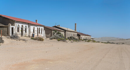 forsaken service buildings on sand at mining ghost town in desert, Kolmanskop,  Namibia
