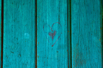 Black painted heart on wooden wall. blue boards background. happy Valentines day.