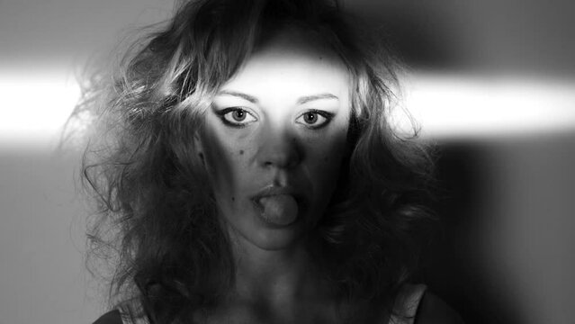 Face, black and white woman chewing gum isolated on a monochrome background in studio. Portrait, blowing bubble and model with candy, eating sweets and beauty of serious girl with light on her eyes