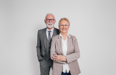 Confident mature businessman and businesswoman in glasses smiling and standing on white background